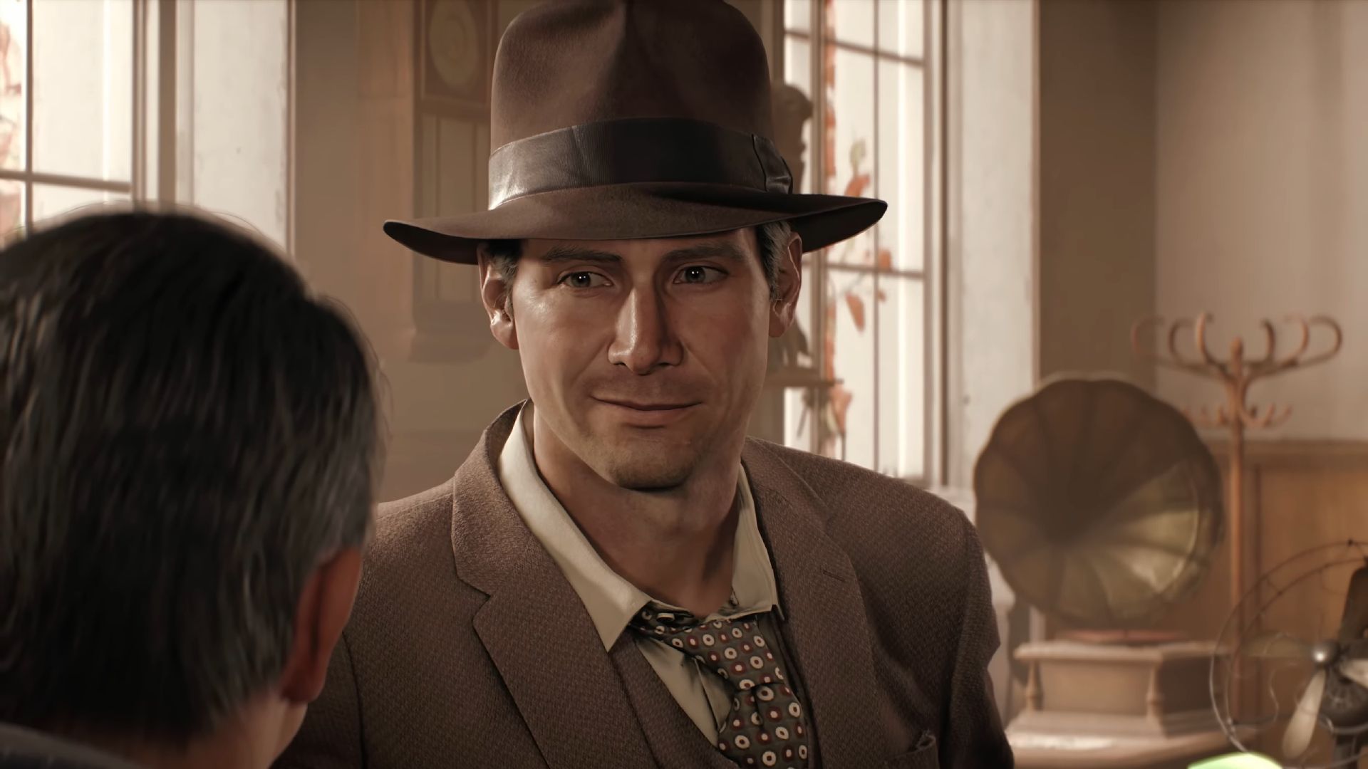 Indiana Jones in a tweed three-piece suit and brown fedora, standing in his office with a phonograph visible in the background, in Indiana Jones and the Great Circle