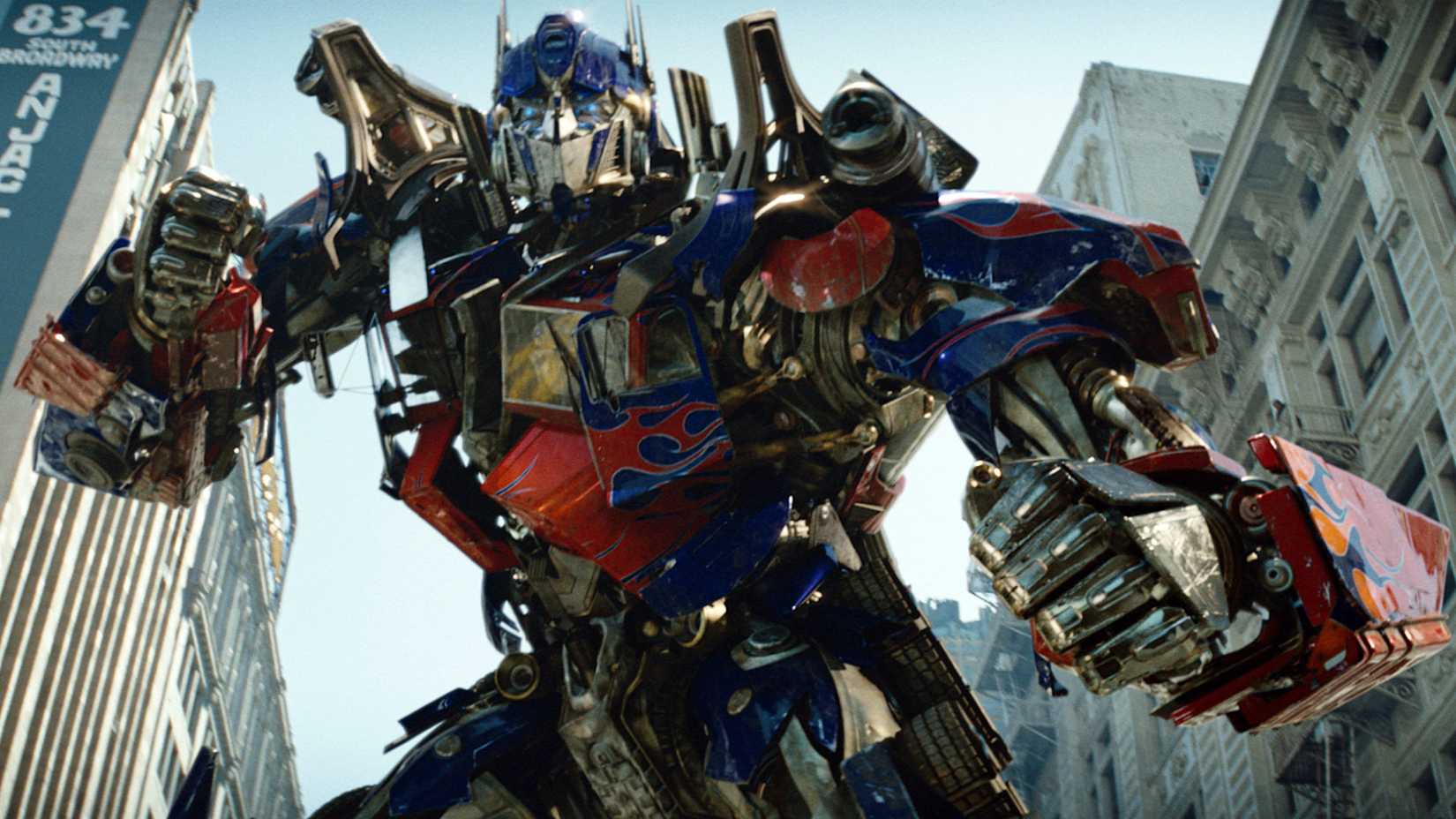 Optimus Prime, a red and blue robot with flame decals, preparing for battle in Transformers