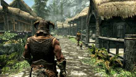 A character in a horned helmet walks through a village in Skyrim