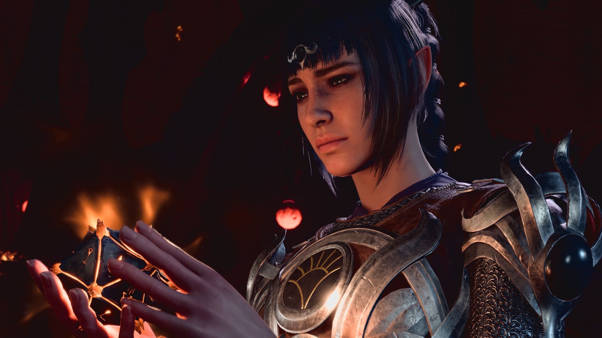 A woman in armor with black hair gazes at a glowing puzzle box