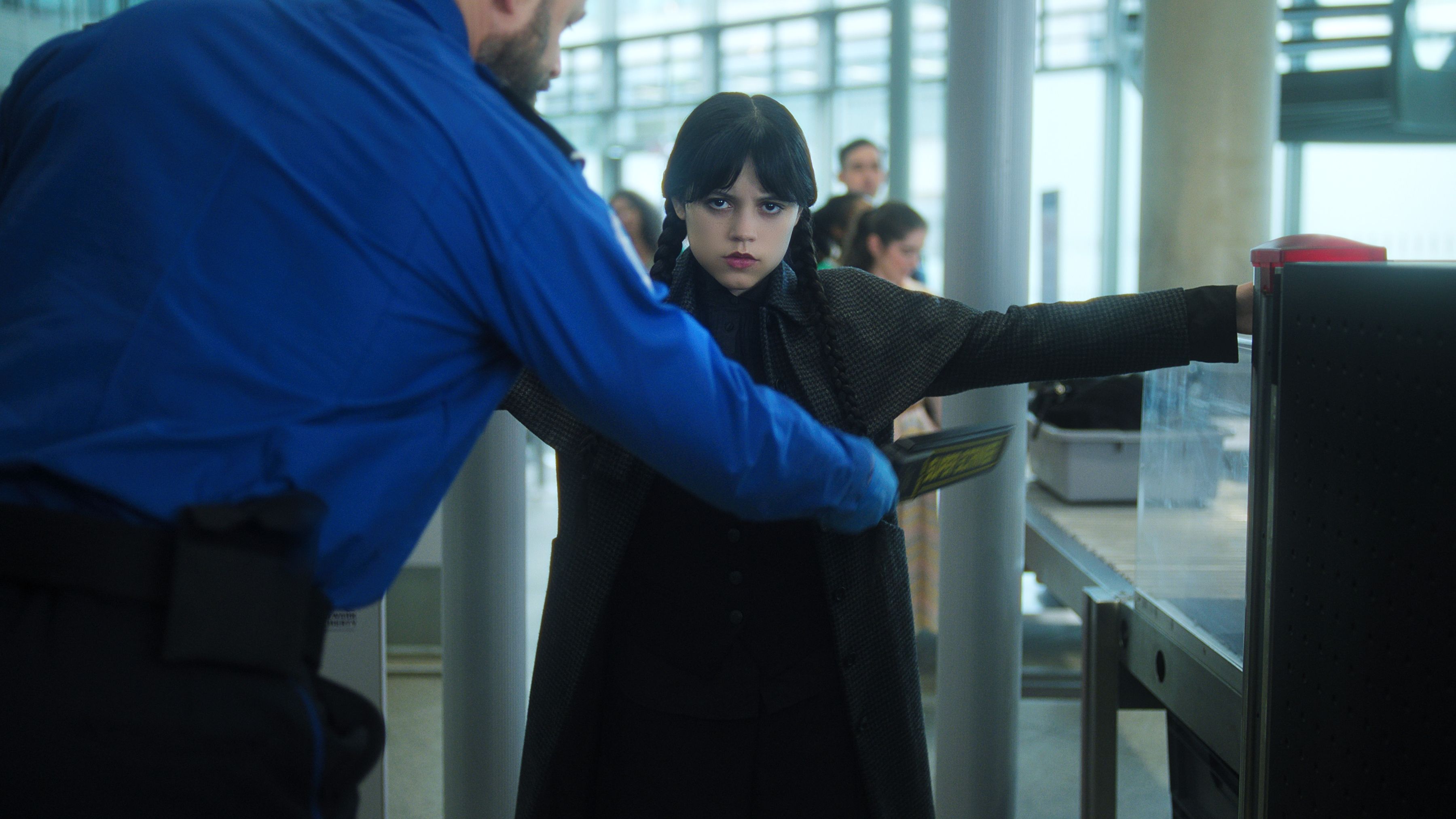 Wednesday Addams, as played by Jenna Ortega, going through airport security in Wednesday season 2