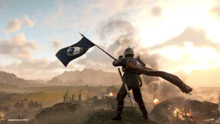 A Helldiver waves a Super Earth flag in a screenshot from Helldivers 2