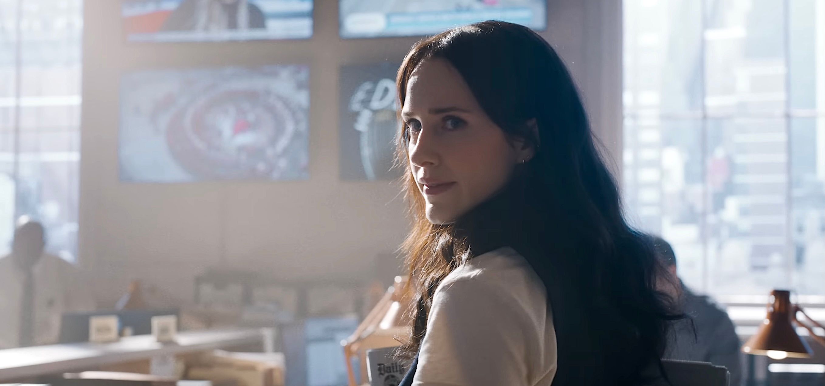 Rachel Brosnahan as Lois Lane in James Gunn’s Superman pauses in the Daily Planet office and looks back over her shoulder