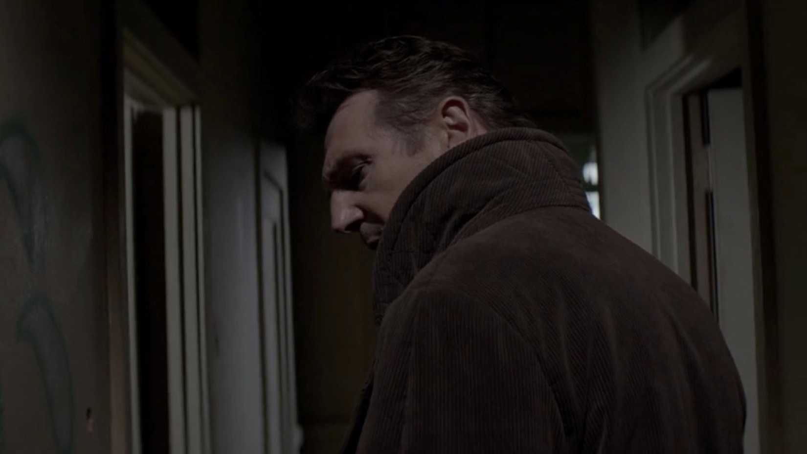 Liam Neeson skulking through a hallway in a scene from the film A Walk Among the Tombstones