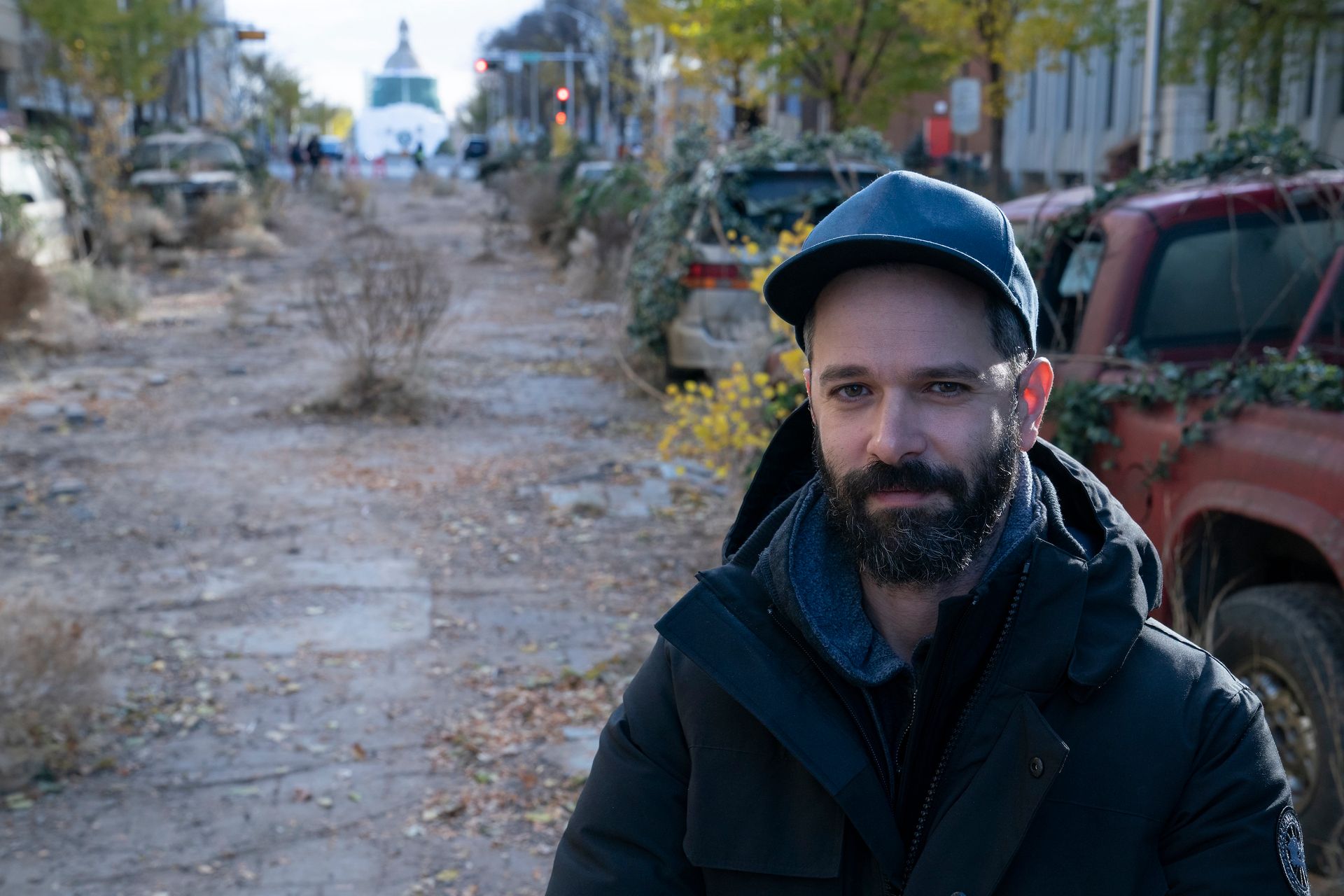 a man, Neil Druckmann, standing in the middle of an empty road on the set of HBO’s The Last of Us The Last of Us Season 1 - Episode 2 The Last of Us season 1, episode 2.