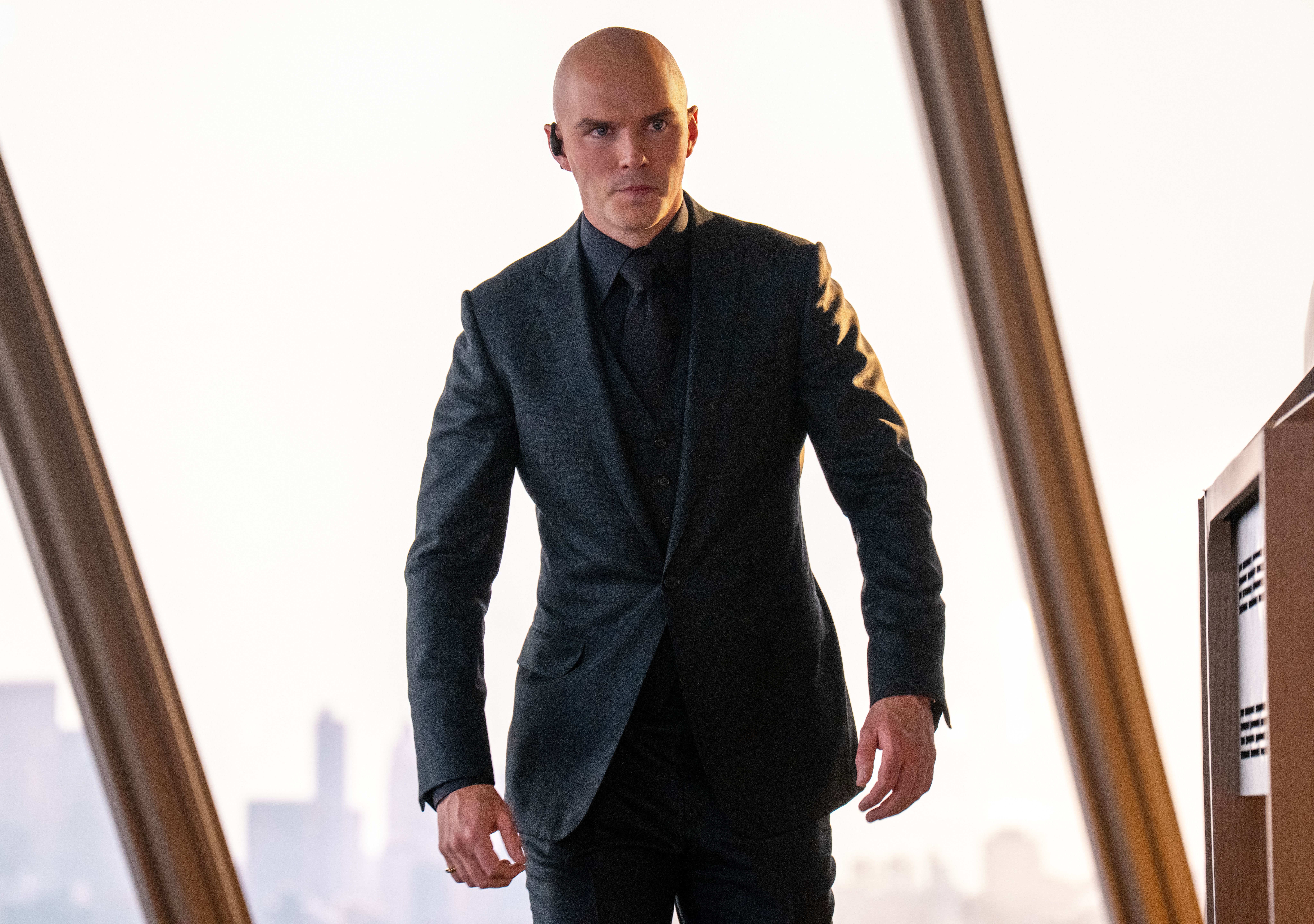 Nicholas Hoult as Lex Luthor stands in front of a window wearing a suit in Superman