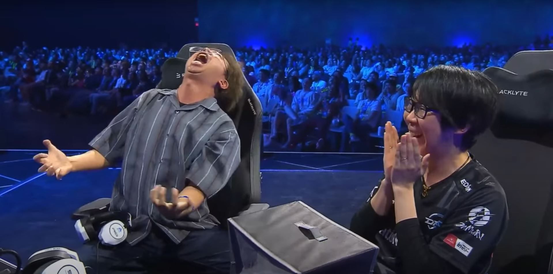 Two competitors at EVO 2025, KojiKOG and Go1, duking it out in Fatal Fury. KojiKog reacts to his defeat with dramatic despair as he silently screams toward the sky, and his competitor Co1 clasps his face in amusement. 