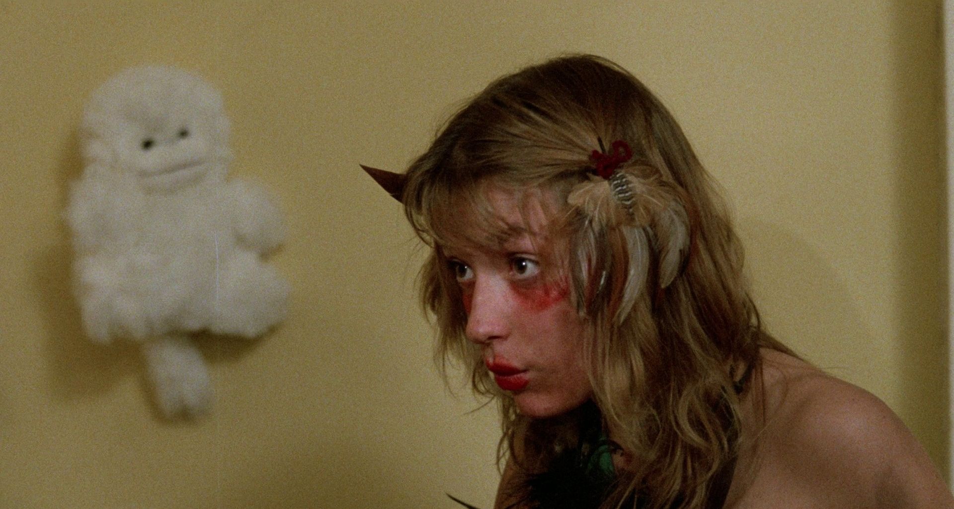 A girl with blood on her face looks intently at something off-screen in Beware! Children at Play