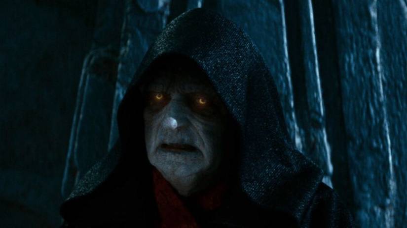Emperor Palpatine in The Rise of Skywalker. his face is covered in shadow and his eyes are glowing intensly.