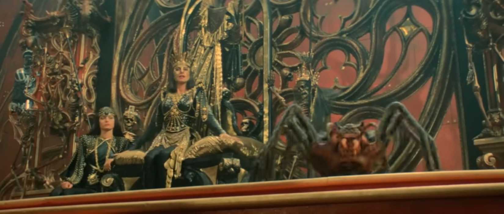 Queen Gedren sits in an ornate set with her gigantic pet spider in a scene from the 1985 Red Sonja film.