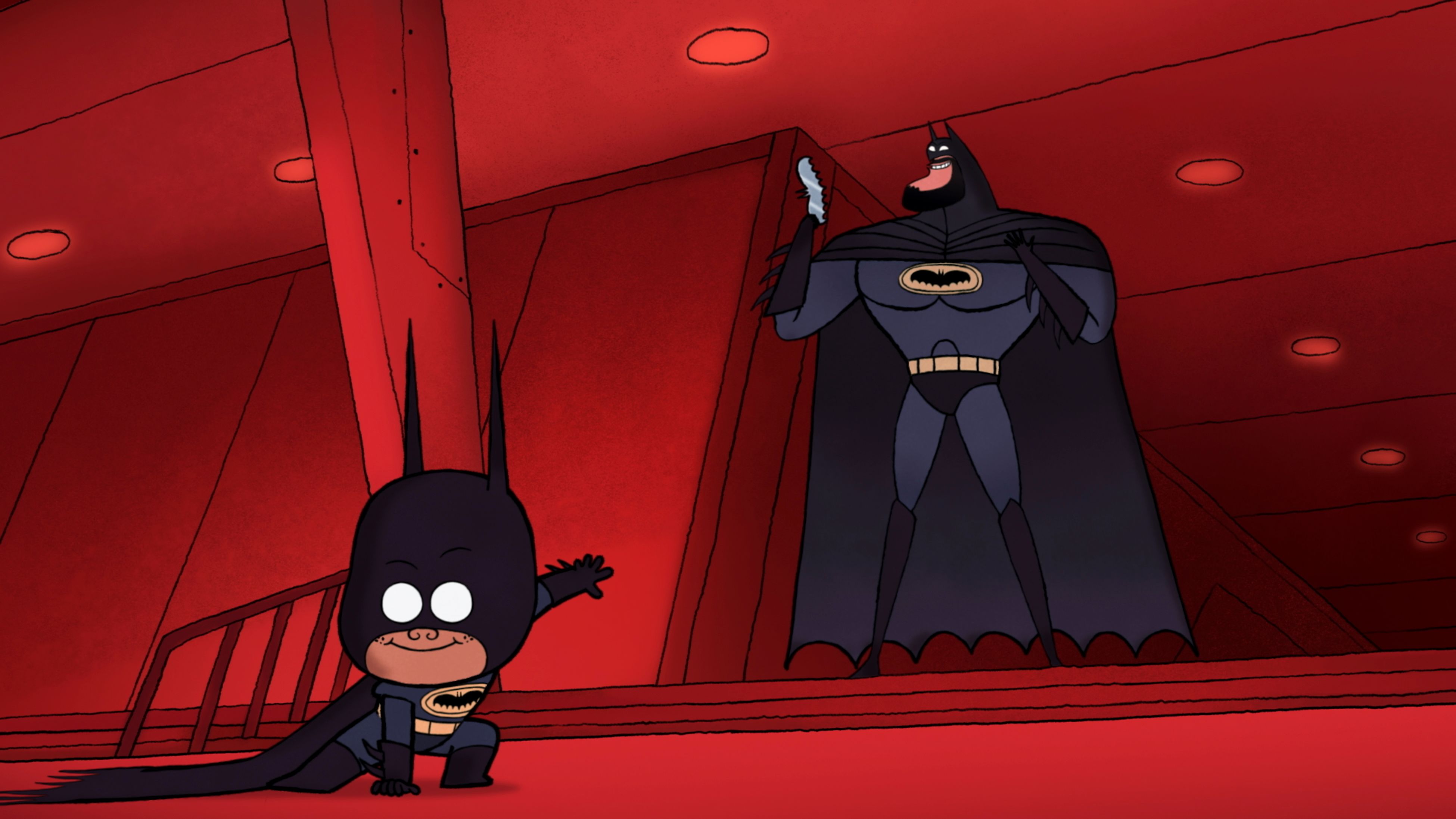 Batman holds a batarang while Damian Wayne in a Batman costume strikes a pose in BAT-MAN