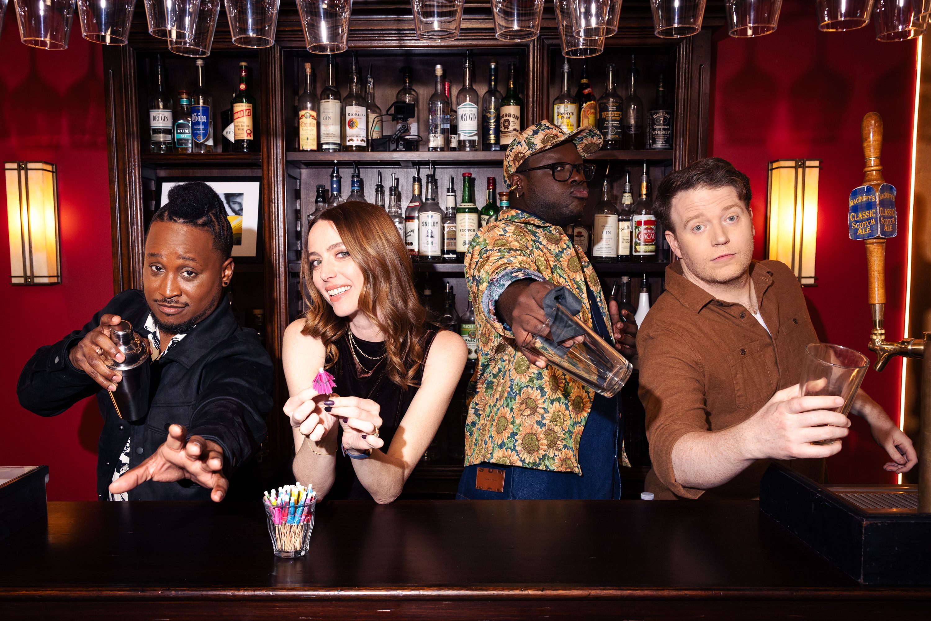 The host and cast of episode 1 of Dropout TV's Crowd Control: Host Jacquis Neal and guests Leah Rudick, Bob The Drag Queen, and Brennan Lee Mulligan, all standing behind the small bar on set