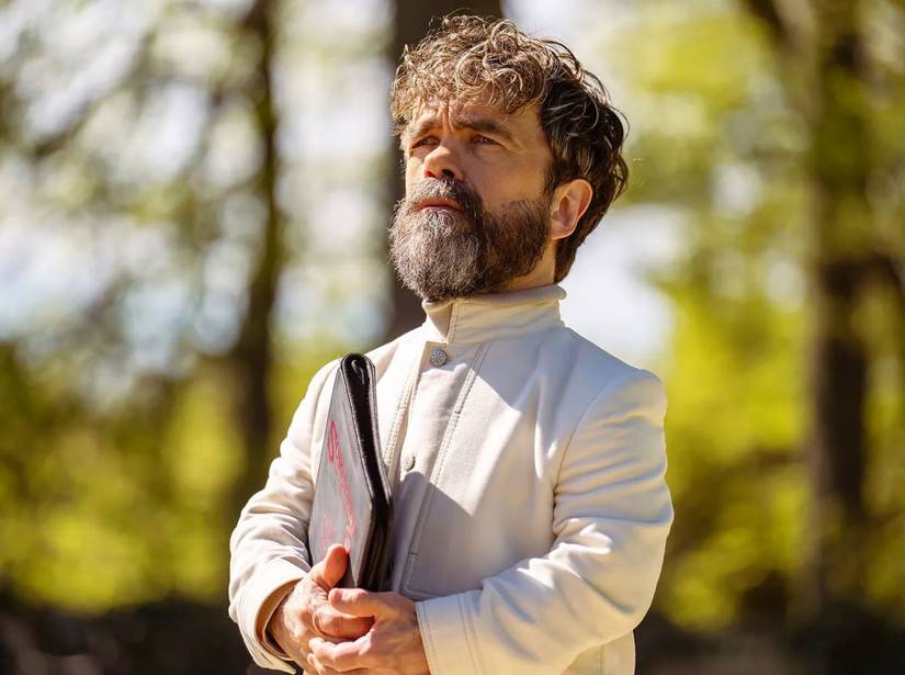 Peter Dinklage holds a binder and stands outside in Dexter Resurrection