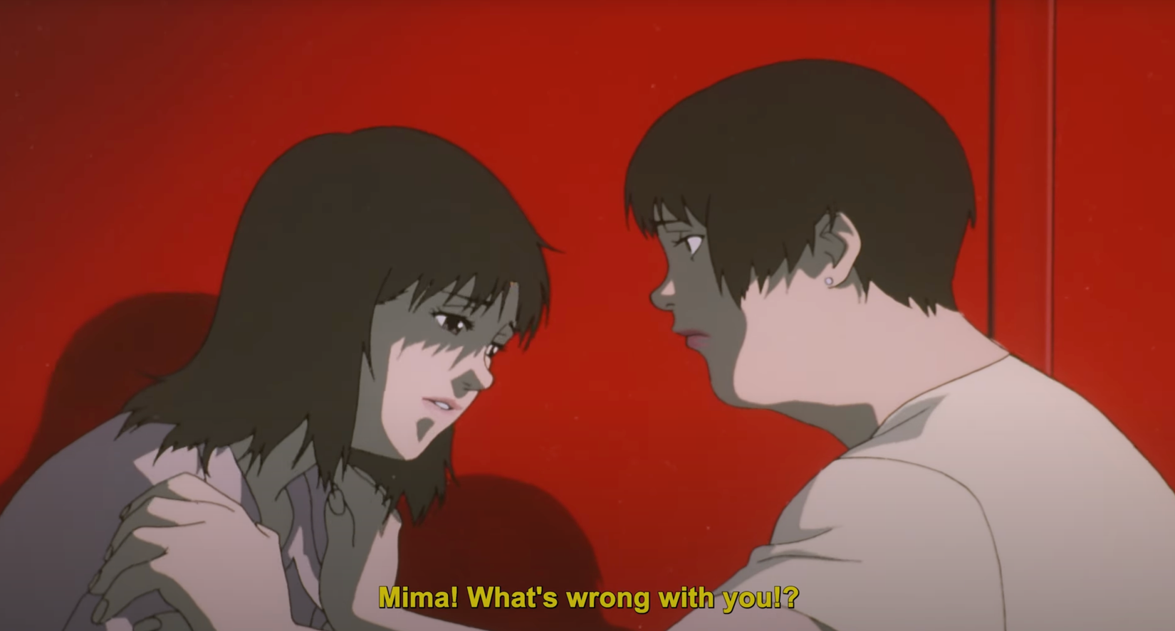 परफेक्ट ब्लू स्टिल: दो महिलाएं एक लाल दीवार के सामने खड़ी हैं