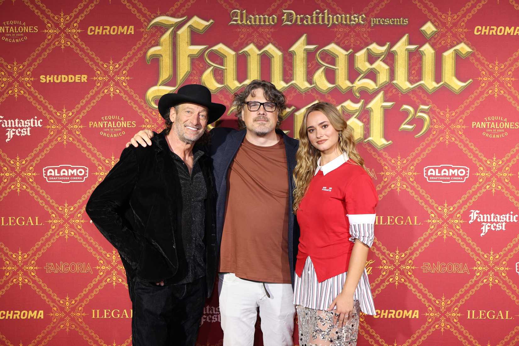The cast and director of Primate in front of a Fantastic Fest 25 sign