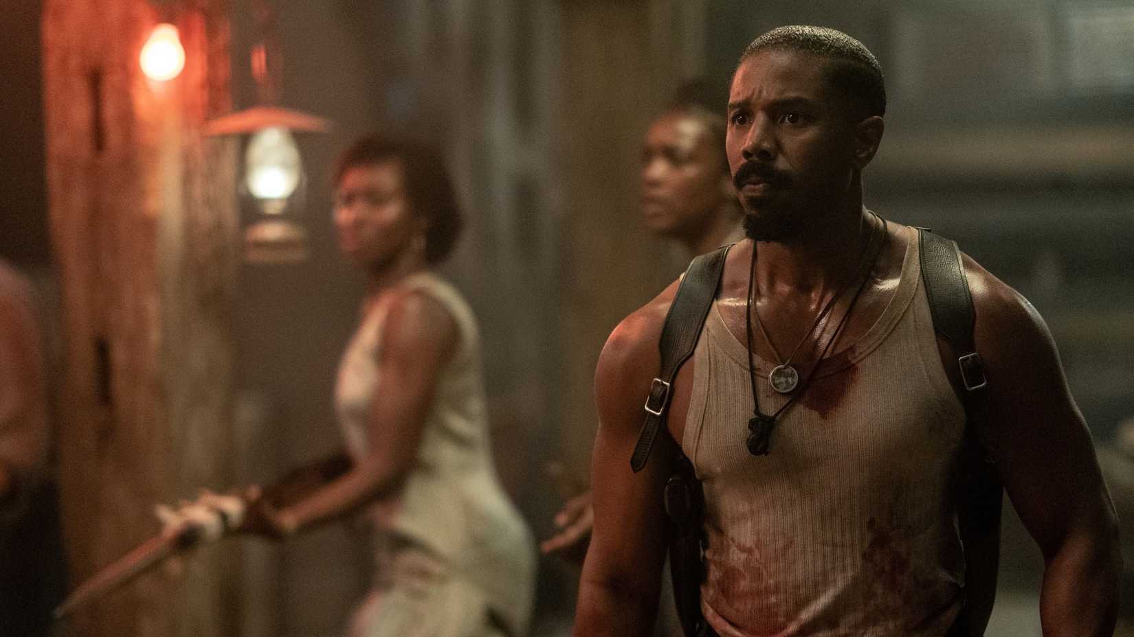 Michael B. Jordan, sweaty and wearing a blood-splattered sleeveless T-shirt, looks troubled and shaken in Ryan Coogler's 