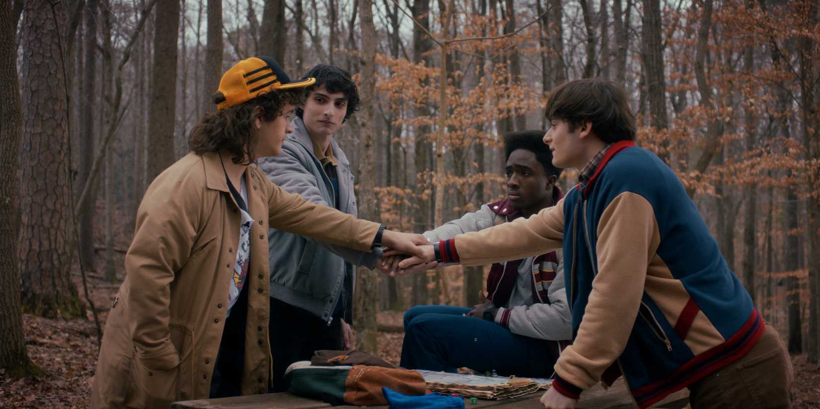 Stranger Things protagonists joining hands in a season 5 scene