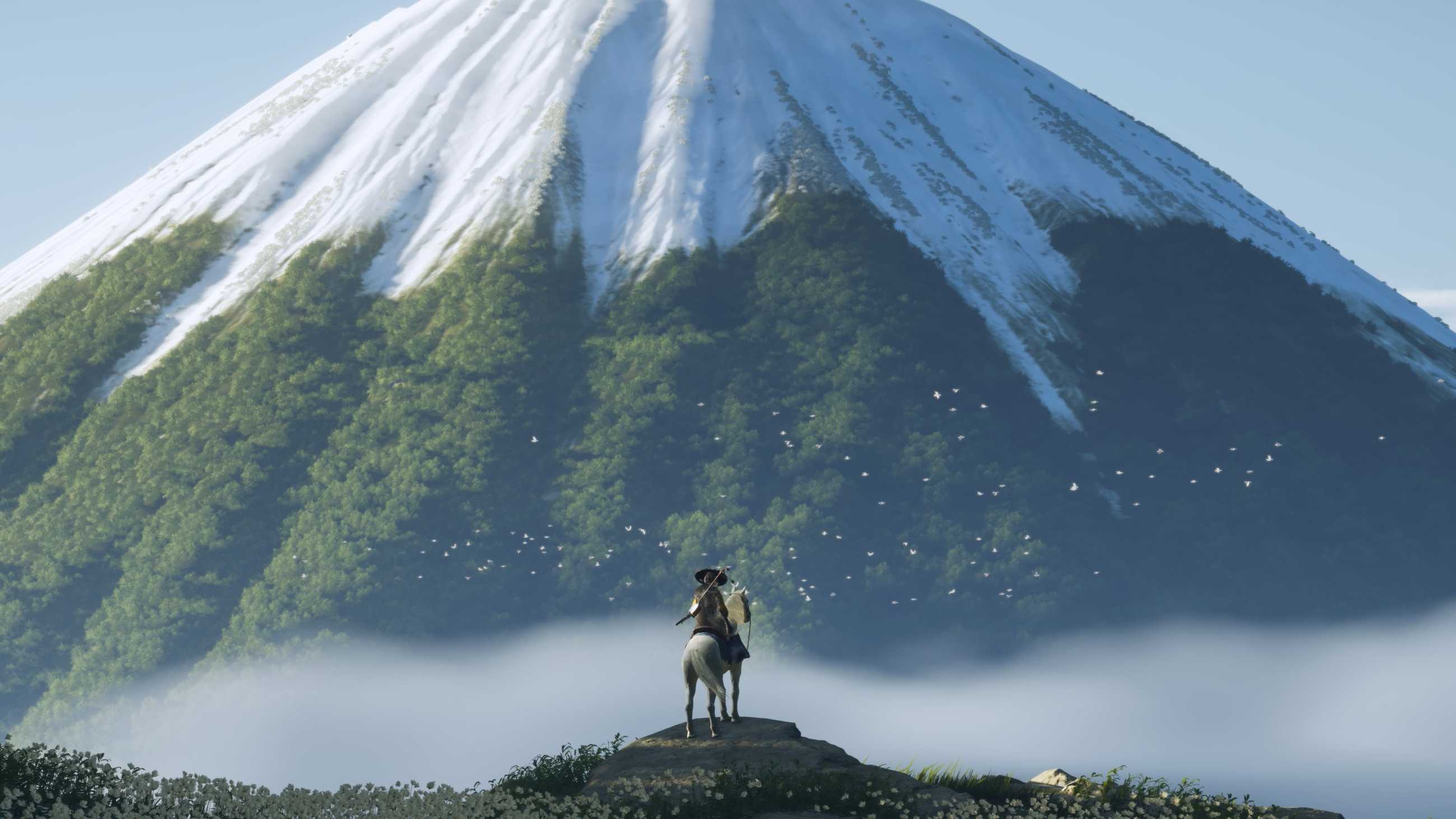 A lone samurai on horseback stands before a snow-capped mountain in Ghost of Yotei