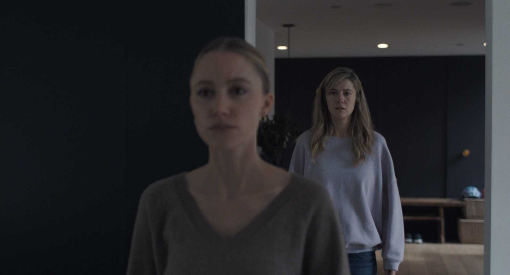 ในฉากหนึ่งจากภาพยนตร์รีเมคเรื่อง The Hand That Rocks the Cradle ในปี 2025 Maika Monroe ในฐานะคุณย่าที่ไม่มั่นคง ยืนอยู่เบื้องหน้า (แต่ไม่อยู่ในโฟกัส) ในขณะที่ Mary Elizabeth Winstead ในฐานะเจ้านายของเธอ มองดูในเบื้องหลัง (แต่อยู่ในโฟกัส) 