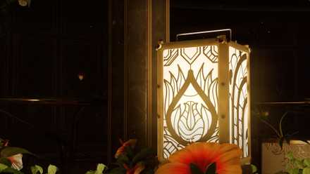 A close-up shot of an ornate lantern with a flower pattern, surrounded by real flowers.