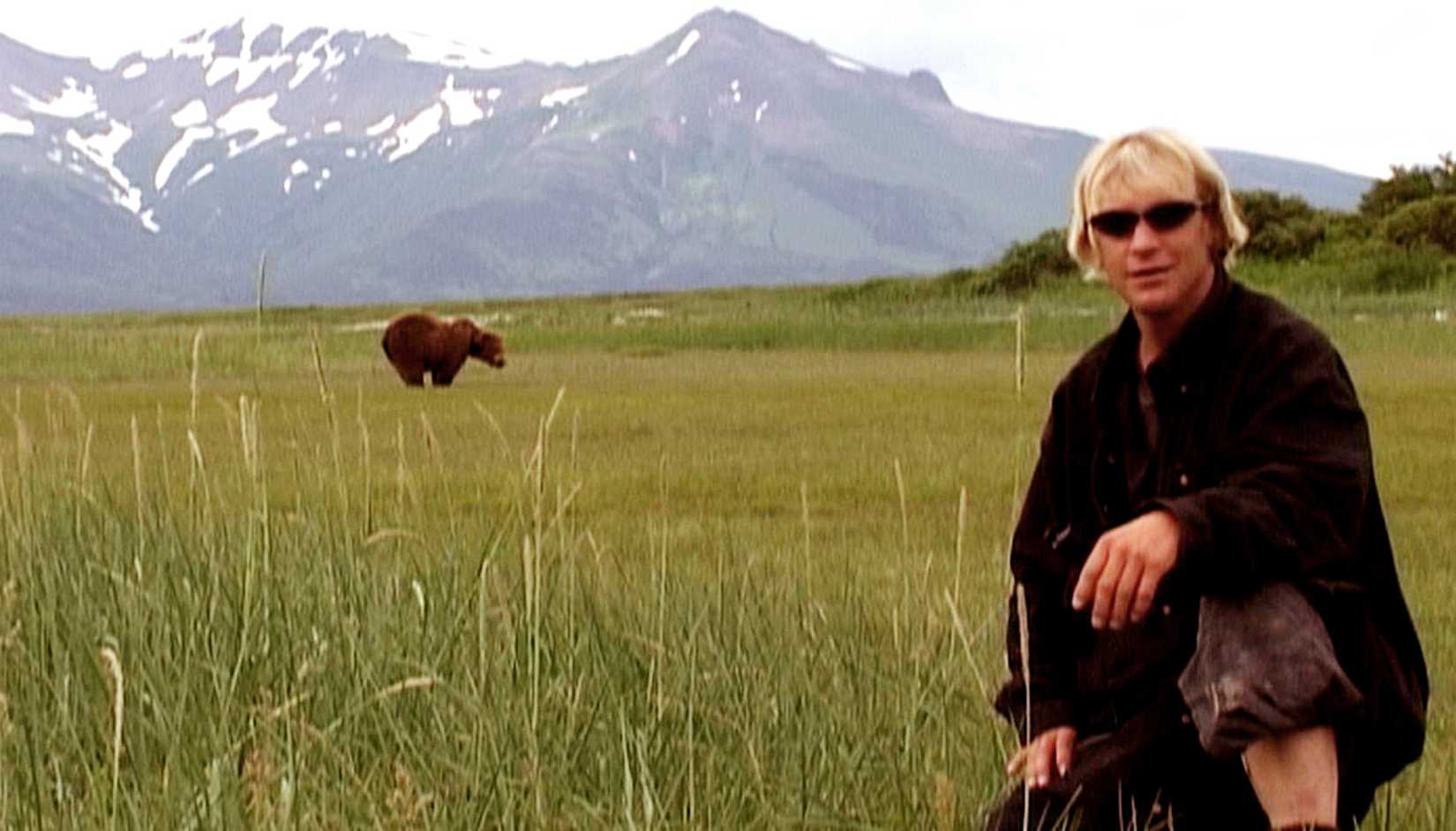 Timothy Treadwell posing in front of a bear in Grizzly Man