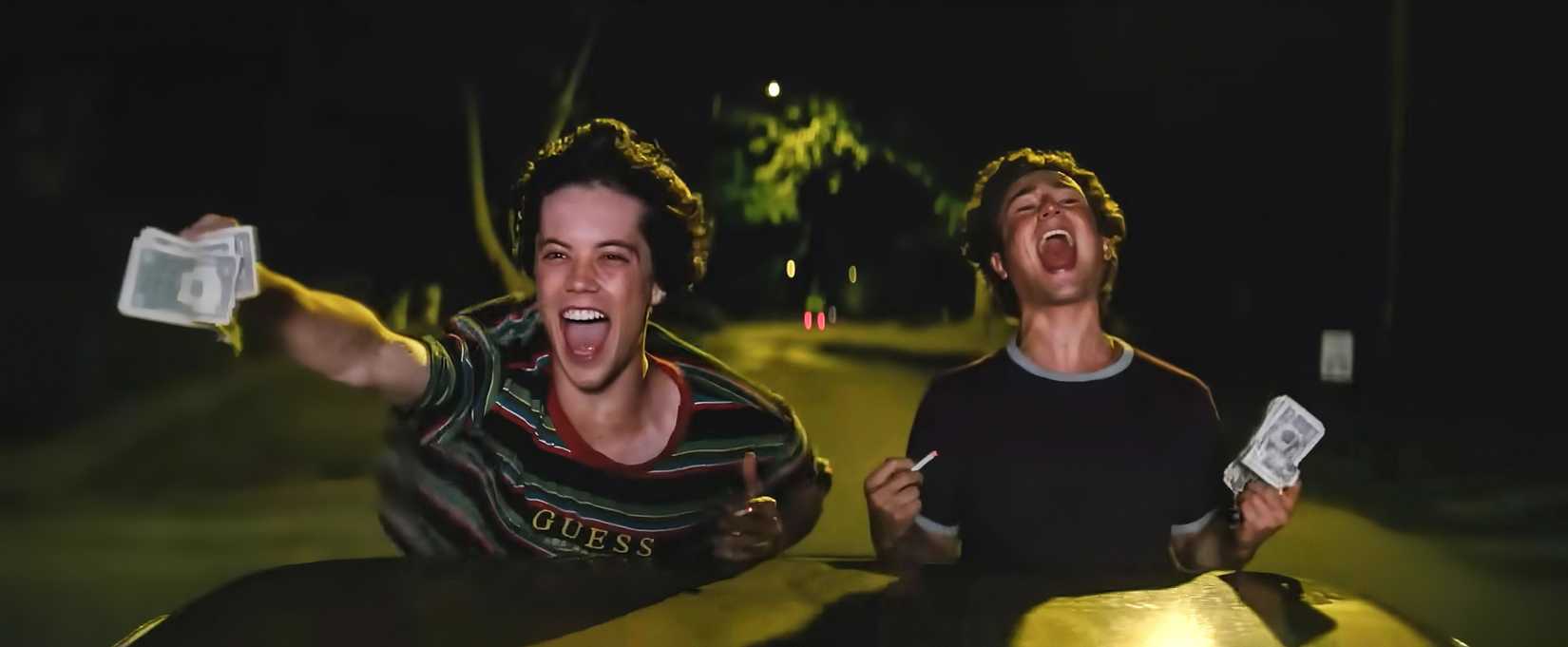 The boys from Snack Shack screaming with cash in their hands as they ride in a car