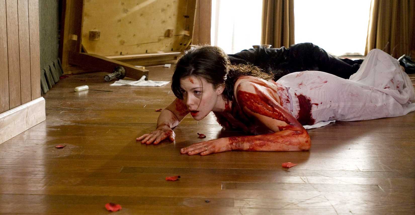 Liv Tyler as a bloodied woman crawling across a wooden floor — still from The Strangers (2008)