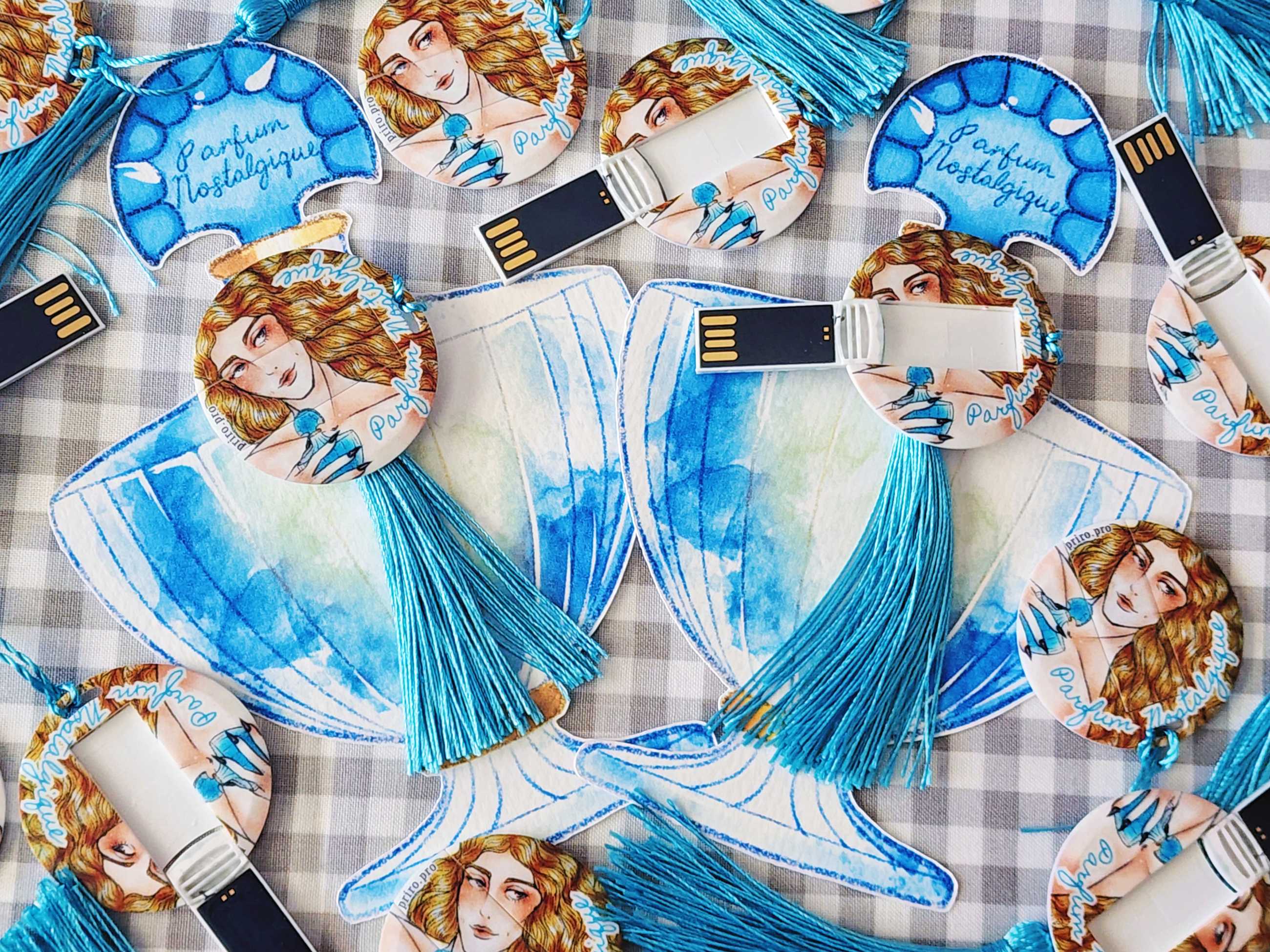 Several physical copies of Parfum Nostalgique displayed; a perfume‑bottle shaped USB is visible among them.