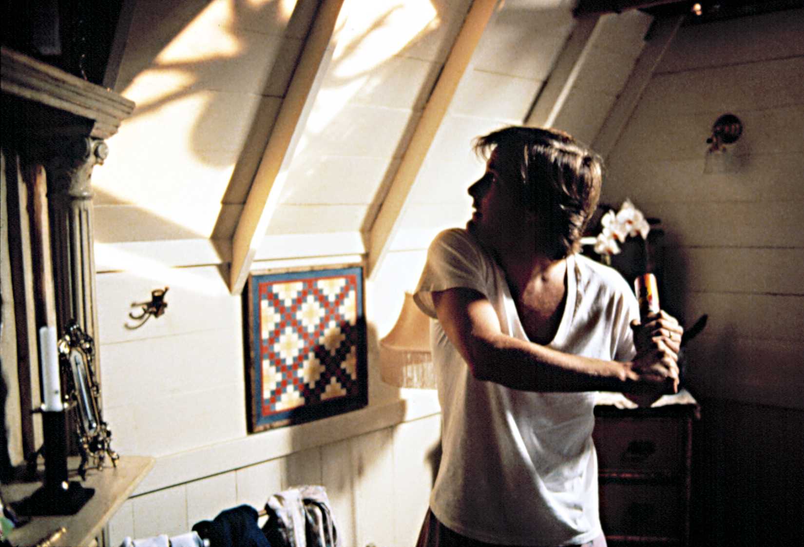 Jeff Daniels prepares to attack a spider on the wall in Arachnophobia