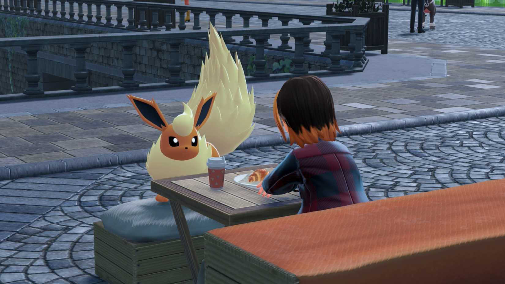 A Flareon stares at its trainer sitting with coffee and a pastry in Pokémon Legends: Arceus.