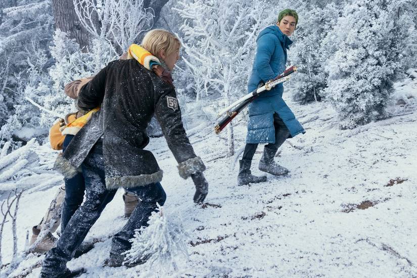 Roronoa Zoro and Sanji trudging up a snowy slope on Drum Island in Netflix's One Piece Season 2
