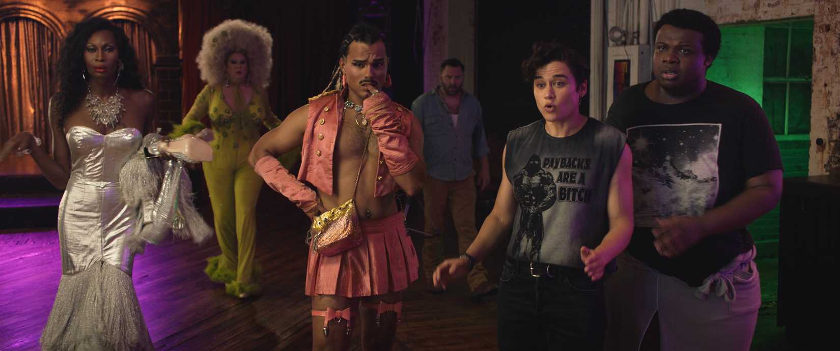 I went with this: A group of characters in Queens of the Dead, all dressed in different forms of fabulous (a silver lamé sleeveless ballgown, a huge puffy white wig and mustard-yellow body stocking, an open vest with no shirt under it, a butchy sleeveless shirt that reads