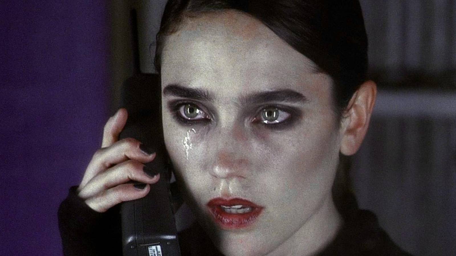 Marion holds the phone up to her ear, wearing heavy makeup as tears stream down her cheeks.