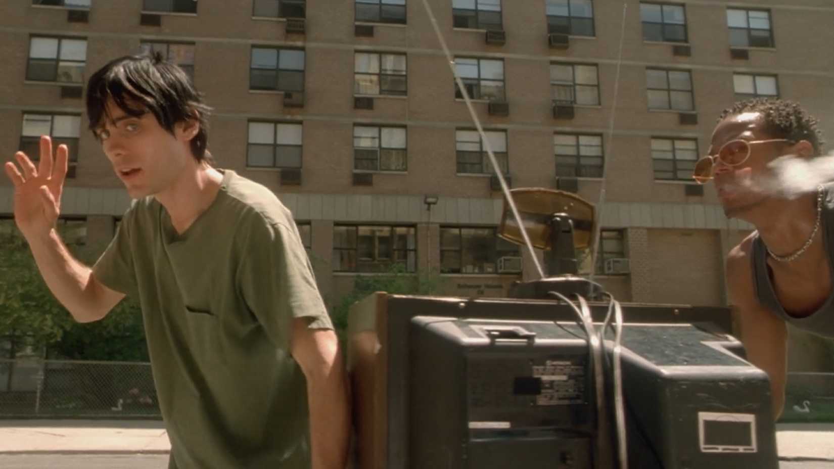 Harry awkwardly waves at his mother's friends as he and Tyrone wheel her TV set off to the pawn shop.