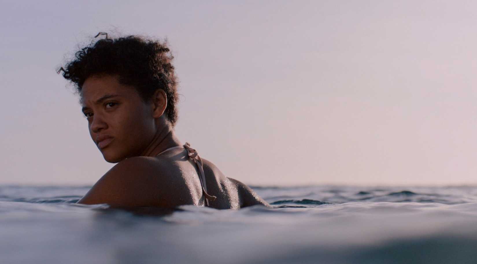 Kiersey Clemons wading in water in a scene from Sweetheart