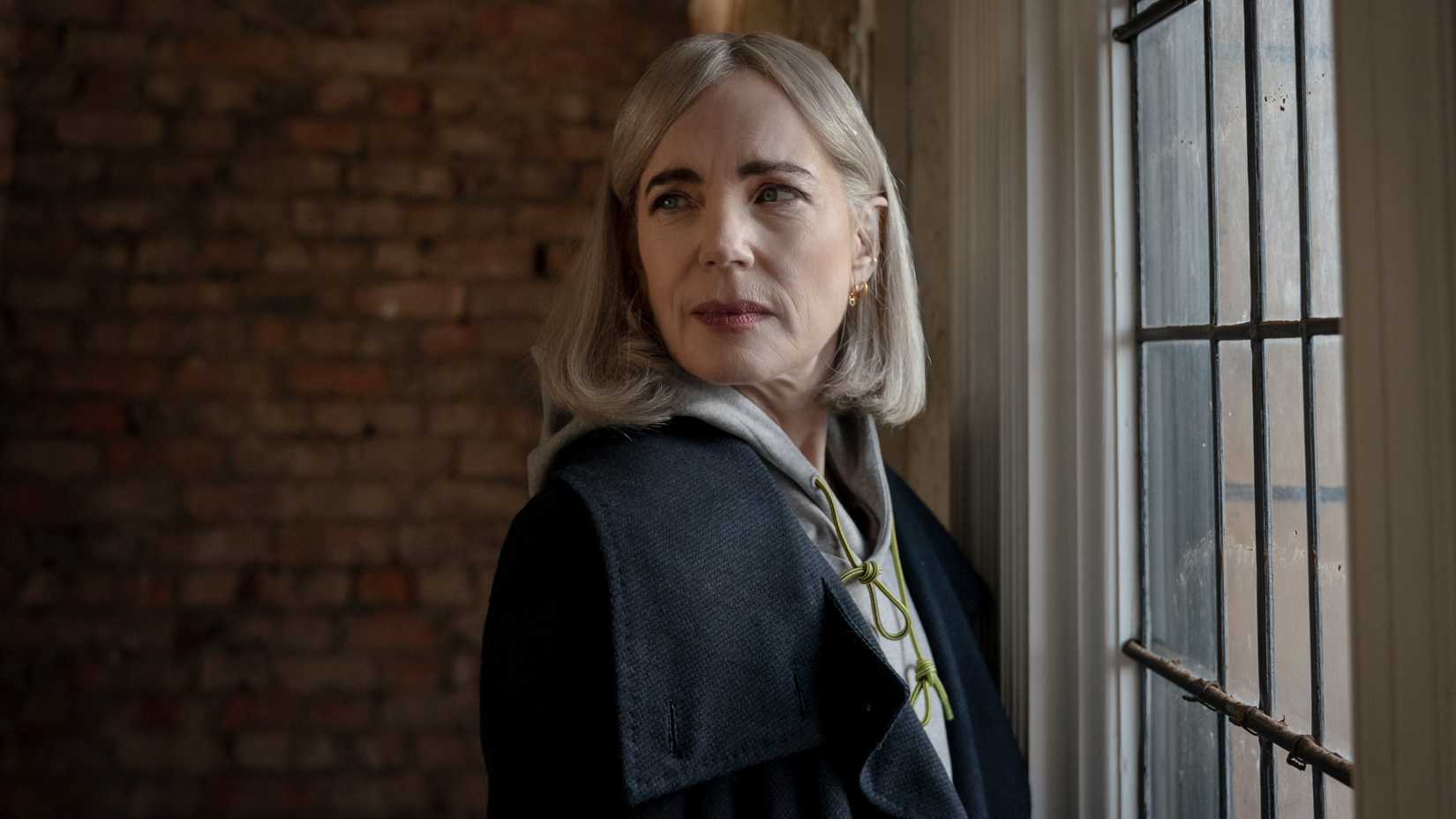 Helen (Elizabeth McGovern) stands near a window in Talamasca