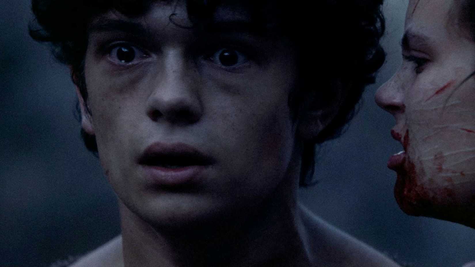 A mysterious stranger whispers something troubling to The Boy, played by Noah Jupe, in The Carpenter's Son.