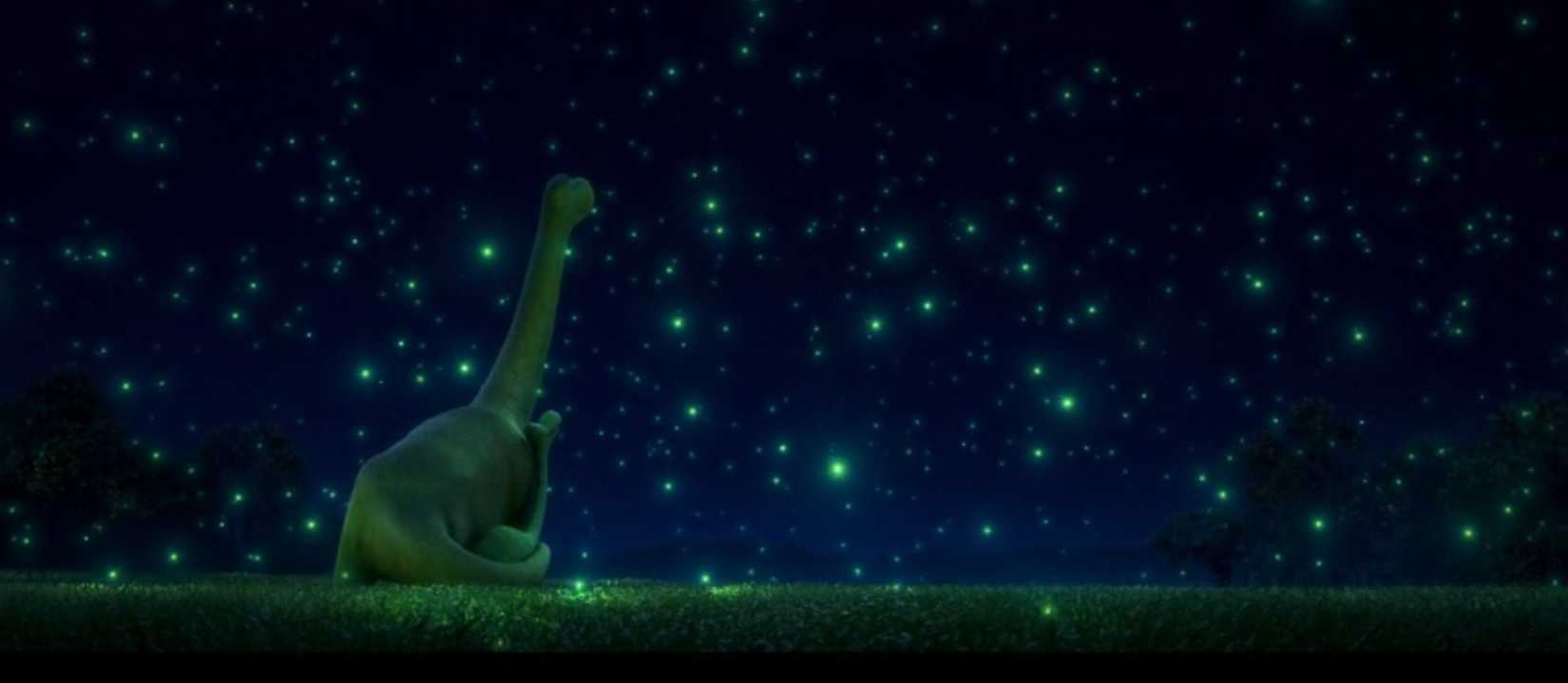 A father and son dinosaur gaze up at bioluminescent bugs that fill the night sky in The Good Dinosaur.
