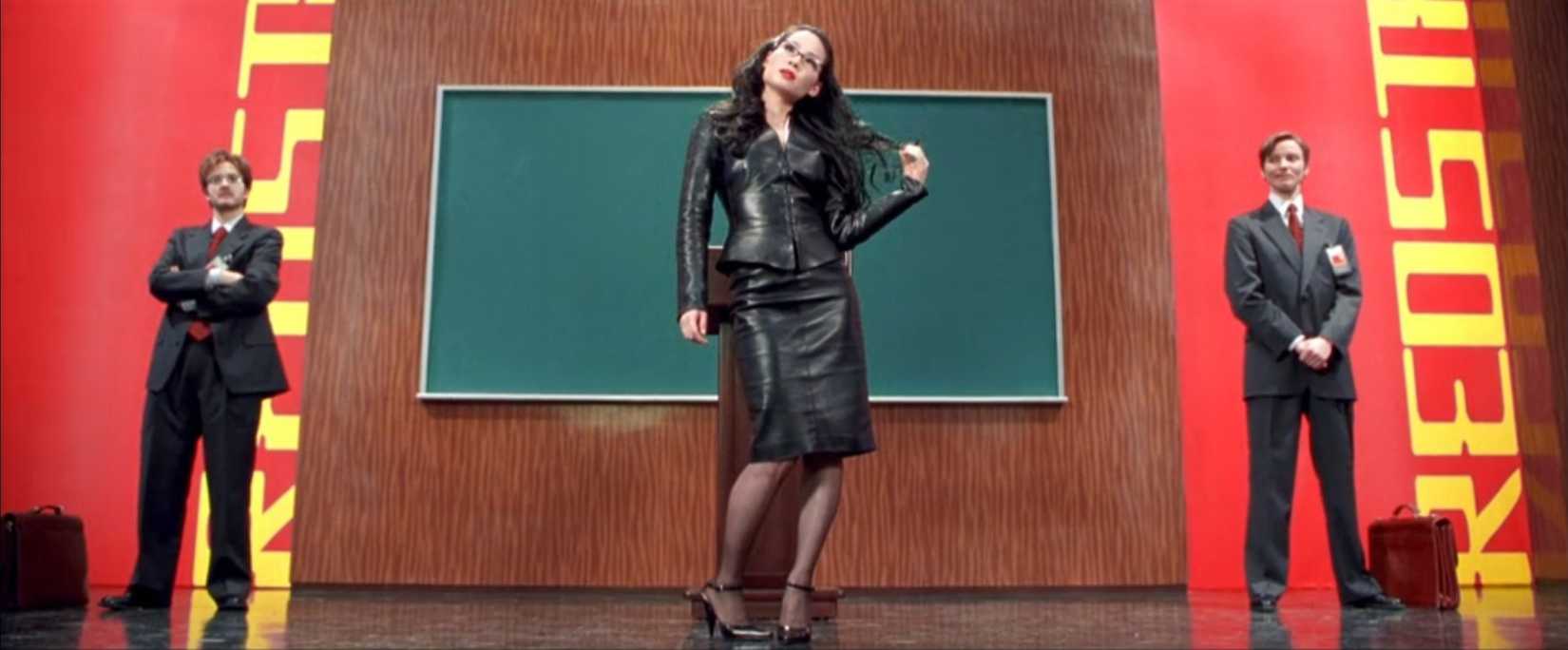 In a scene from Charlie's Angels, Lucy Liu, undercover as an efficiency expert, toys with company men as a distraction from a heist