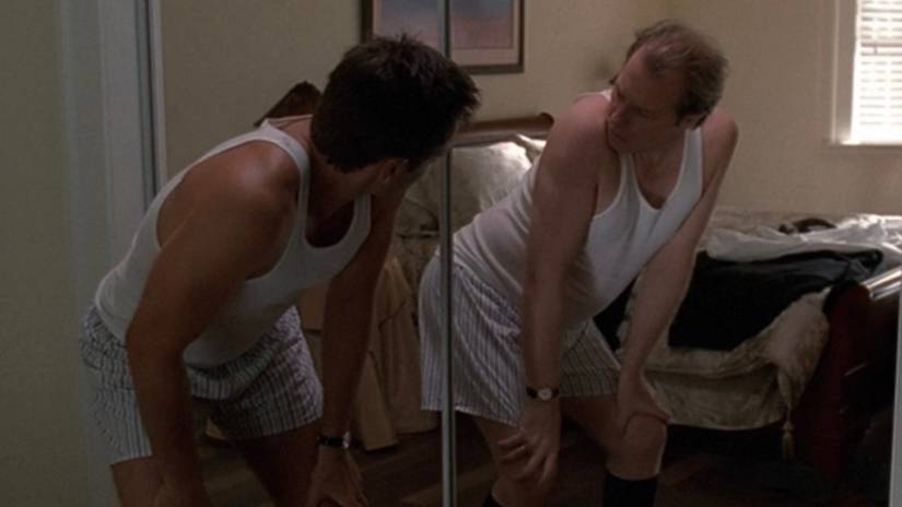 Fox Mulder (David Duchovny) shakes his butt while looking in the mirror where he sees Morris Fletcher (Michael McKean) in The X-Files episode Dreamland