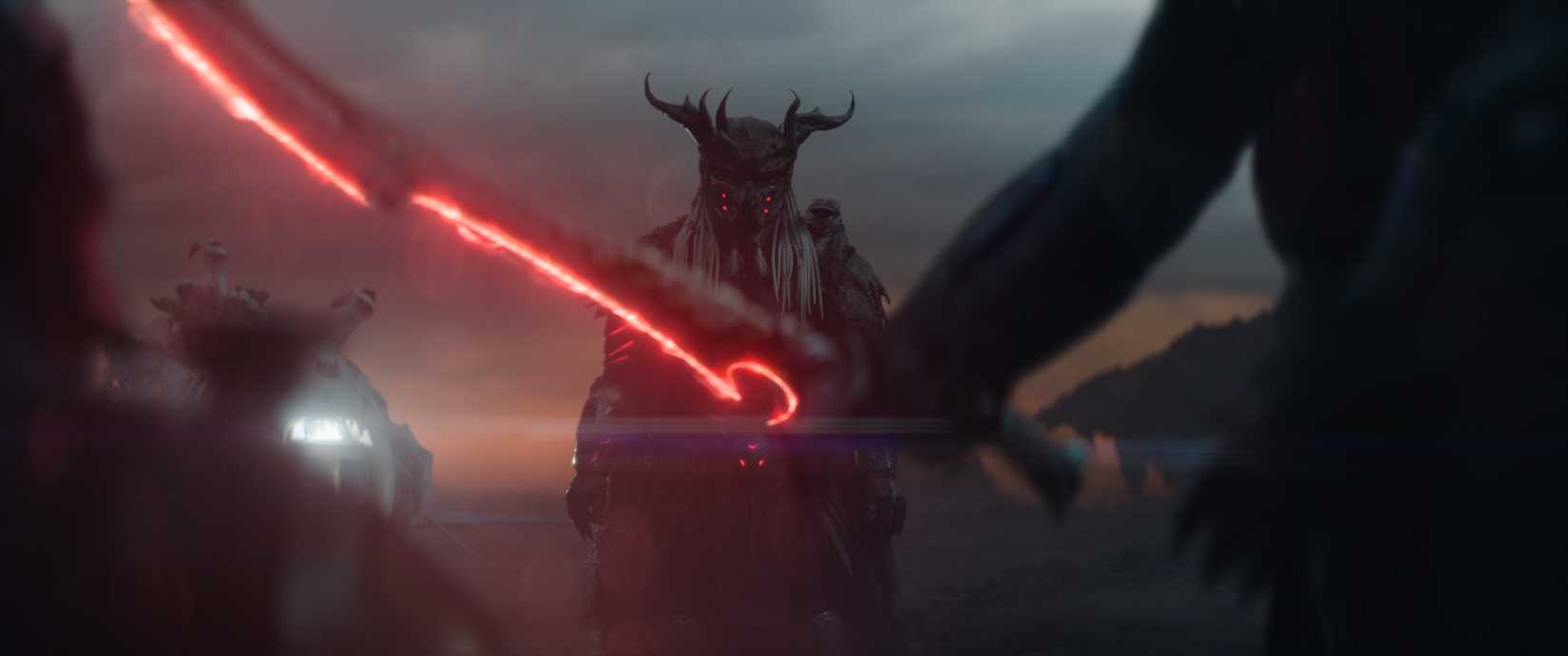 A silhouetted figure with a glowing red futuristic sword faces off against an armored Predator in a horned helmet in Predator: Badlands