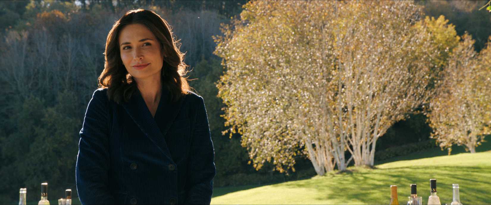 Smiling woman in a field of golden trees, Pluribus