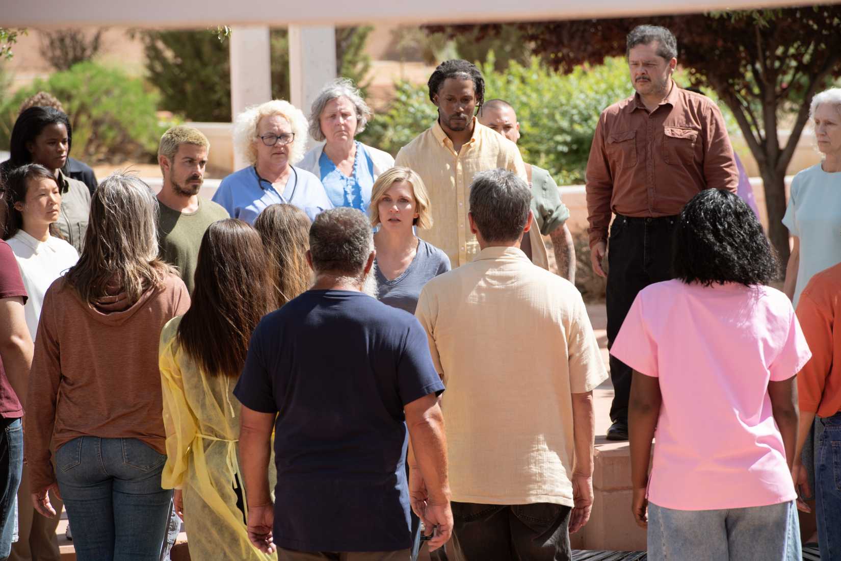 Carol (Rhea Seehorn) looks worried as people coalesce in a circle around her in Pluribus episode 4