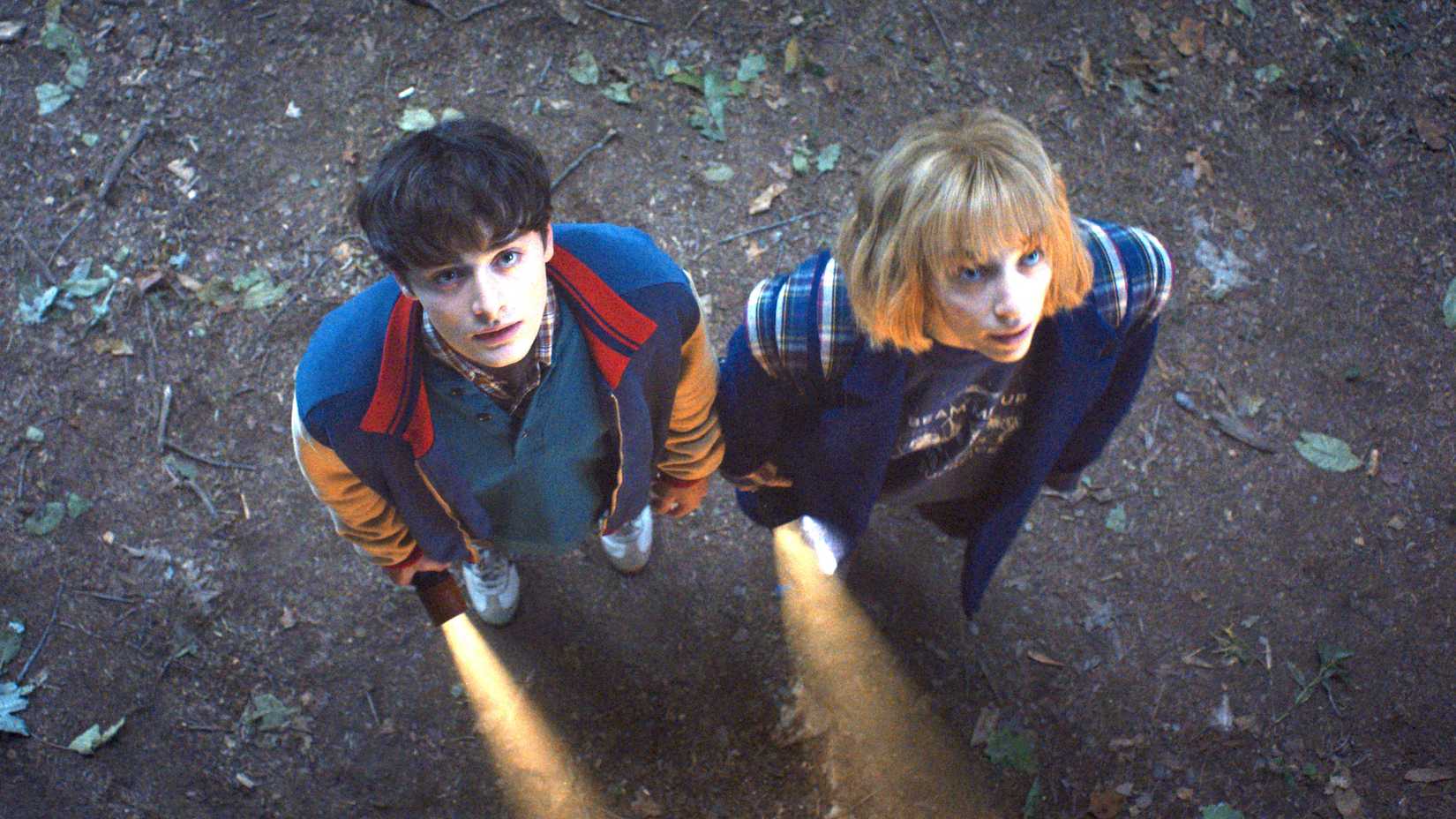 Noah Schnapp as Will Byers and Maya Hawke as Robin Buckley hold flashlights in Stranger Things season 5