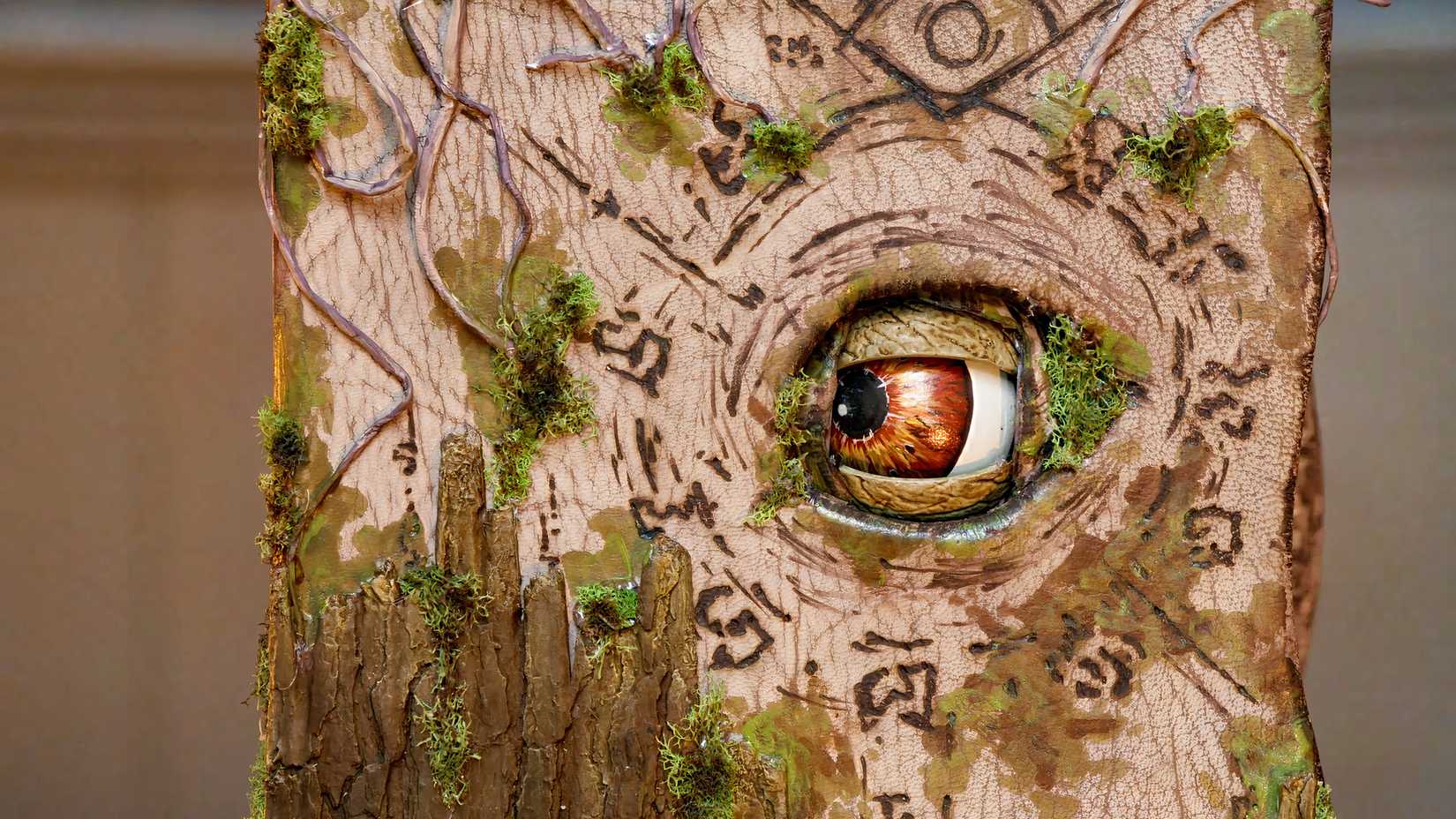 An image of a gnarled, wooden spellbook with an animatronic eye featured in Tales From Woodcreek.