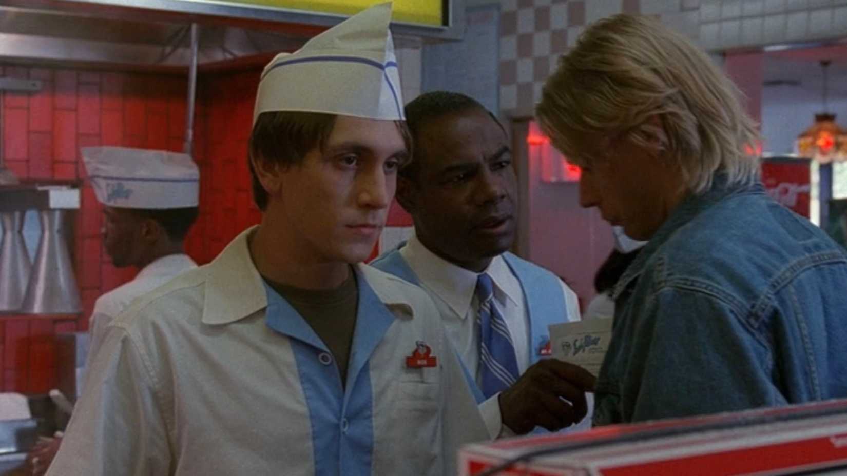 A fast-food worker (Chad Donella) looks upset while his coworkers argue in The X-Files episode 