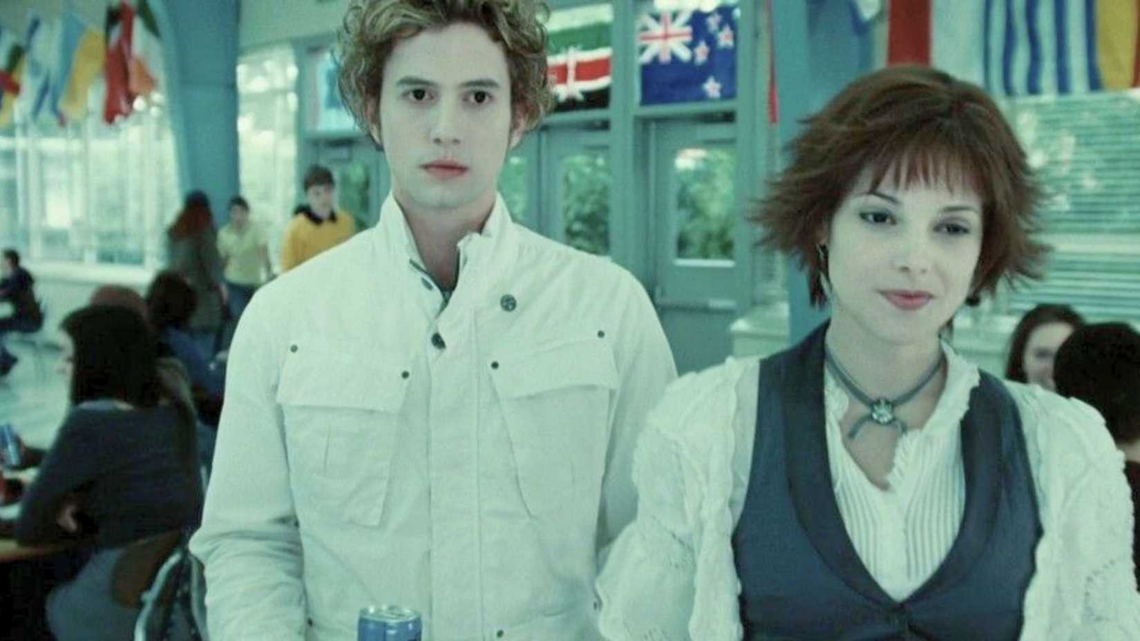 Jasper and Alice (Jackson Rathbone and Alice Greene) walk side-by-side in a lunch cafeteria. 