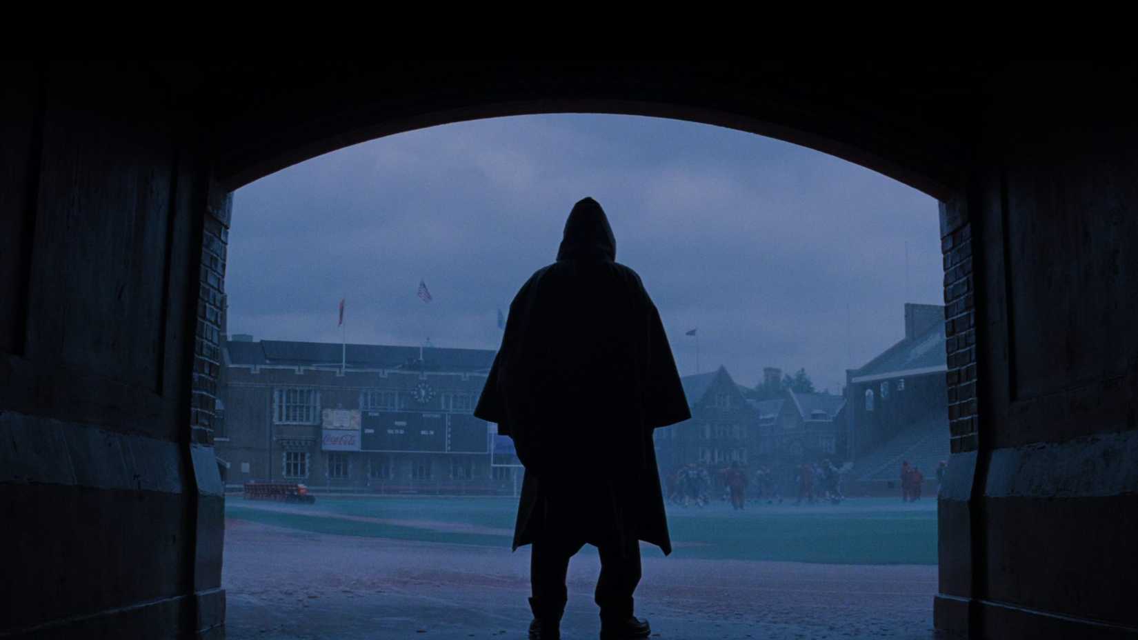 Bruce Willis (David Dunn) standing in the rain in a raincoat from Unbreakable