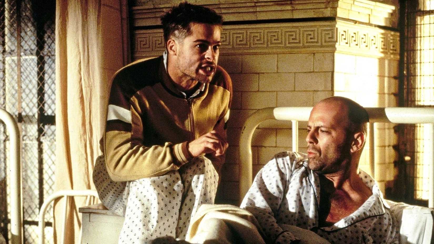 Two inhabitants of a mental institution -- a wild-eyed, energetic revolutionary played by Brad Pitt and a time-traveler played by Bruce Willis -- converse in a scene from Terry Gilliam's film 12 Monkeys.