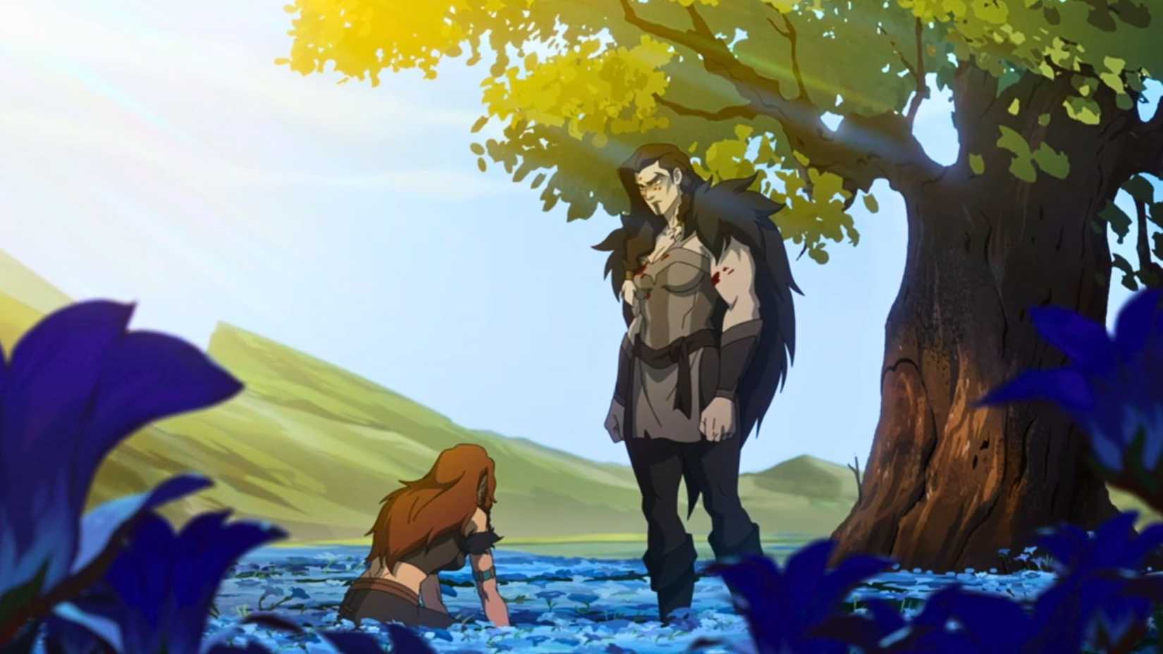 An image from The Mighty Nein. It shows Yasha, a strong, muscular barbarian woman standing among a field of blue flowers. A woman with brown hair kneels in front of her.